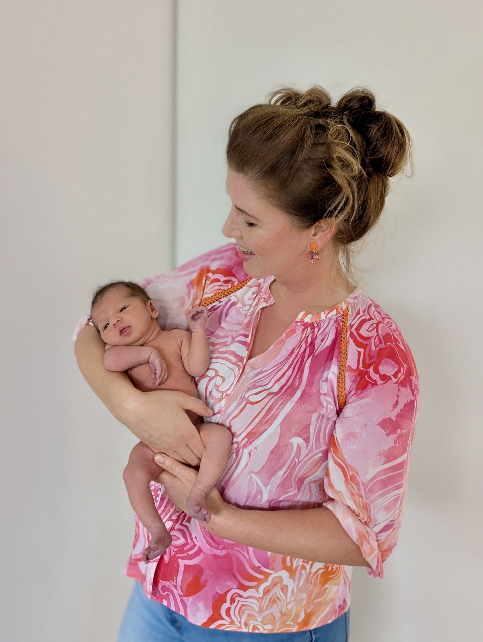 Hebamme Dorothee hält ein frisches Baby auf dem Arm